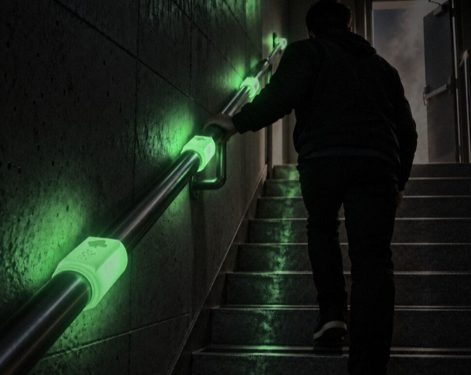Visualisation: a person climbs a dark stairwell while DALIL clips glow green along the handrail.
